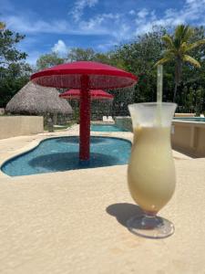 una bebida sentada en una mesa junto a una piscina en Aurora Luxury Suite con acceso a la playa en Chame