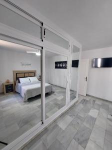 Schlafzimmer mit einem Bett und Glasschiebetüren in der Unterkunft Apart Aleire Pueblo Evita in Benalmádena