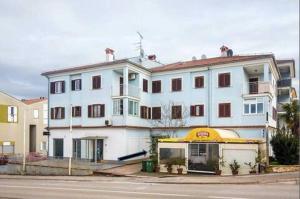 a large white building on the side of a street at Apartment Little Gallery **** in Rovinj