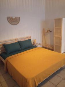 a bedroom with a bed with a yellow blanket at Studio 'Katerina by the Sea' in Salamina