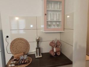 a kitchen counter with a cupboard and some cups at Studio 'Katerina by the Sea' in Salamina