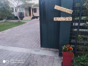 een deur naar een huis met een bord dat modern huis leest bij WOODEN HOUSE in Preveza
