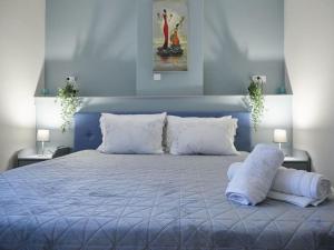 a blue bedroom with a large bed with white pillows at Casa di Andreo in Faraí
