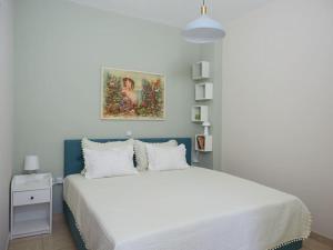 um quarto com uma cama branca e um quadro na parede em Casa di Andreo em Faraí