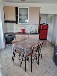 コストレナにあるLori Apartmentのキッチン(テーブル、椅子、赤い冷蔵庫付)