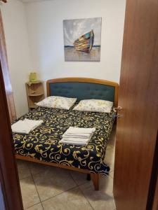 małą sypialnię z łóżkiem z ręcznikami w obiekcie Lori Apartment w mieście Kostrena