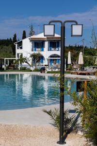 a pole next to a swimming pool in front of a house at Sun 'n Chill, Boutique Apartments & Beach Villa in Melíkia