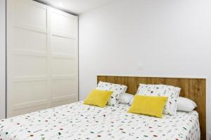 a bedroom with a bed with two yellow pillows at Vacacional in Laredo
