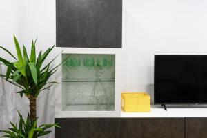 a shelf with green glass vases and a television at Vacacional in Laredo