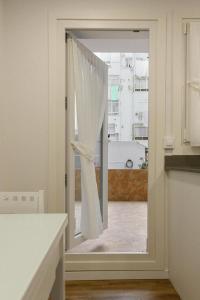 a door with a window with a curtain in a kitchen at Vacacional in Laredo +7 photos