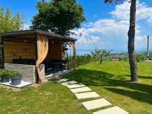 een houten prieel in een veld met een boom bij Apartmaji Meli.Pu 4 in Izola