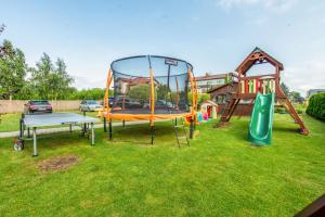 a playground with two slides and a trampoline at KARMAZYNOWY RAJ in Dąbki