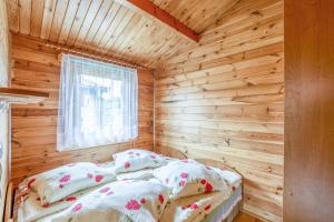 a bedroom with a bed in a wooden cabin at KARMAZYNOWY RAJ in Dąbki