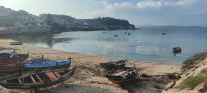 a group of boats on the shore of a beach at Apartamento Praia Naval in Isla de Arosa