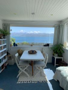 a dining room with a table and a view of the ocean at Tighnamara-Skye in Saasaig