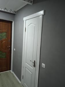 a white door in a room next to a wooden door at Pidkova in Verkhovyna