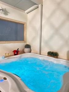 eine Badewanne mit blauem Wasser in einem Zimmer in der Unterkunft La casa di Apollo in Acireale