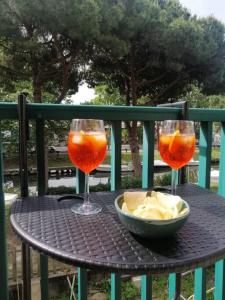 una mesa con dos copas de vino y un tazón de patatas fritas en CasaConte Guesthouse, en Viareggio