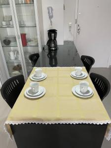 Una mesa con cuatro tazas y platillos. en Esquina da Av Brasil, en Balneário Camboriú