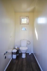 łazienka z toaletą i oknem w obiekcie Glempings Bērzciema Lagūna w mieście Bērzciems