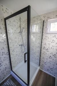 W łazience znajduje się prysznic ze szklanymi drzwiami. w obiekcie Glempings Bērzciema Lagūna w mieście Bērzciems
