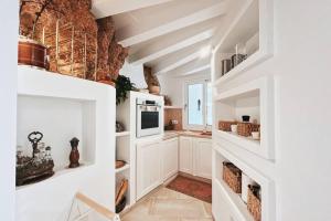 cocina con armarios blancos y chimenea en Luxury House 80m2 Terrace en Cala Morell