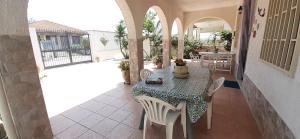 un patio con mesa y sillas en una casa en Lighthouse Gabbiano Azzurro, en Villaggio San Leonardo