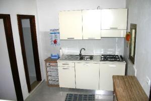 a small kitchen with white cabinets and a sink at Ervilia in Vieste