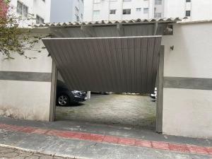 un garaje con un coche aparcado bajo un edificio en Esquina da Av Brasil, en Balneário Camboriú