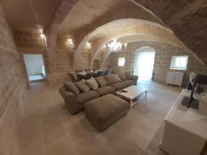 uma grande sala de estar com um sofá e uma mesa em Farmhouse Villa with Large Pool and Garden in Gozo em Għarb