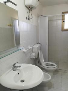 a white bathroom with a sink and a toilet at Ervilia in Vieste