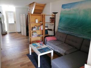 a living room with a couch and a table at Océane in Gujan-Mestras