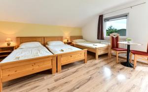two beds in a room with a table and a window at House Krizmanić in Grabovac