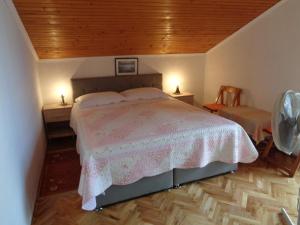 a bedroom with a bed with a wooden ceiling at Pansion Danijela in Rogoznica