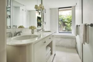 a white bathroom with two sinks and a window at Grand-Hôtel du Cap-Ferrat, A Four Seasons Hotel in Saint-Jean-Cap-Ferrat