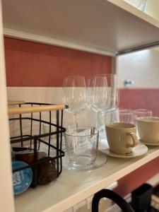 a kitchen counter with wine glasses on a shelf at CASA 300 in Piran