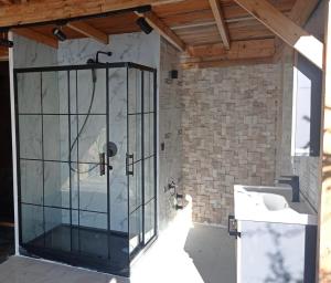 a glass shower in a bathroom with a sink at Mandalina Suites in Kaş