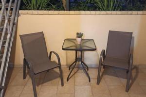 two chairs and a table with a vase on it at Bed and Garden in Kanoni