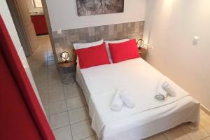 a bedroom with a white bed with red pillows at Bed and Garden in Kanoni