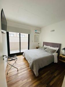 a bedroom with a large bed and a large window at Depto de lujo con pileta en San Telmo in Buenos Aires