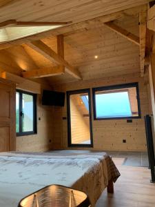 a room with a bed and two windows in a cabin at l'écureuil, chez le charpentier d'antan, au calme, spacieux T3 duplex, ambiance chalet, vue dégagée et parking privé in Epagny Metz-Tessy