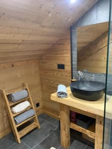 ein Badezimmer mit einem schwarzen Waschbecken und einer Holzwand in der Unterkunft l'écureuil, chez le charpentier d'antan, au calme, spacieux T3 duplex, ambiance chalet, vue dégagée et parking privé in Epagny Metz-Tessy