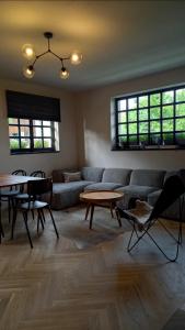 ein Wohnzimmer mit einem Sofa, Tischen und Fenstern in der Unterkunft Villa Luna in Sedlec
