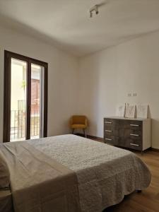 a bedroom with a bed and a dresser and a window at Modern renovated apt in center in Scicli