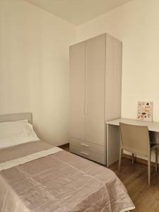 a bedroom with a bed and a desk and a cabinet at Modern renovated apt in center in Scicli