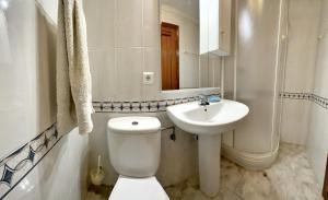 a white bathroom with a toilet and a sink at Isla Mar - 5833 in Isla +25 photos