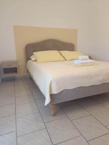 a bed in a bedroom with a tiled floor at Kuca za odmor Vugica in Polje +144 photos