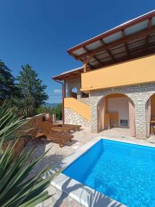 a villa with a swimming pool and a house at Kuca za odmor Vugica in Polje