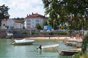 a group of people on a beach with boats in the water at Isla Mar - 5833 in Isla