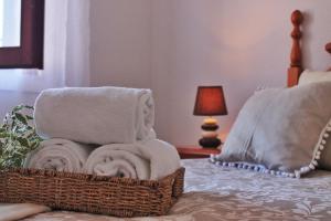 a basket of towels on a bed with a lamp at A Babor - 20805 in Argoños